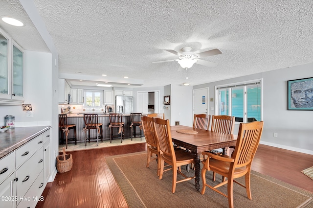 dining space with dark wood-style floors, ceiling fan, a textured ceiling, recessed lighting, and baseboards