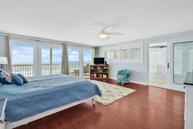 bedroom with access to outside, a textured ceiling, wood finished floors, baseboards, and a ceiling fan
