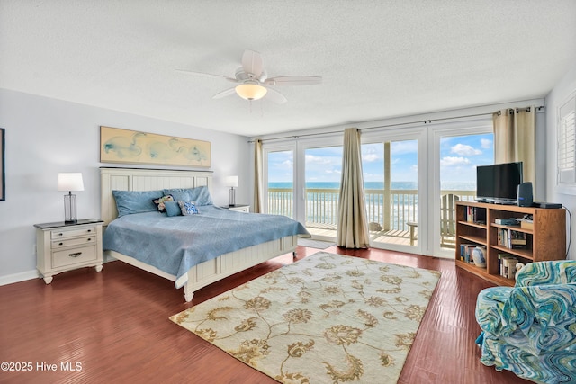 bedroom featuring access to exterior, a textured ceiling, wood finished floors, a ceiling fan, and baseboards