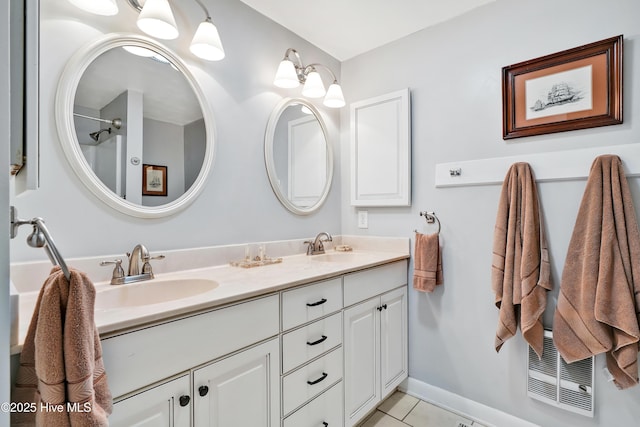 bathroom featuring double vanity, tile patterned flooring, and baseboards
