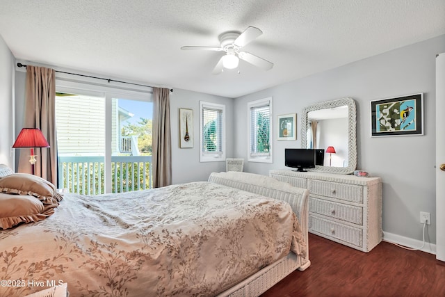 bedroom with multiple windows, dark wood-style flooring, access to outside, a textured ceiling, and a ceiling fan