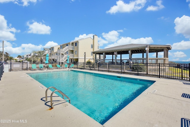 community pool with fence and a patio