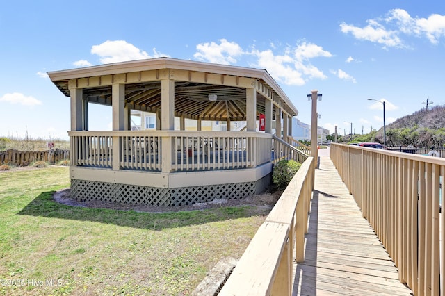rear view of property with a yard, a gazebo, and a wooden deck