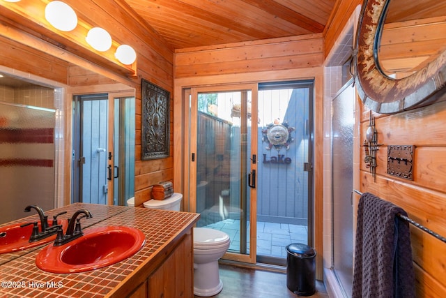 105 Tucker Ct, West End, NC 27376 - bathroom with toilet, vanity, a stall shower, wood walls, and wood finished floors