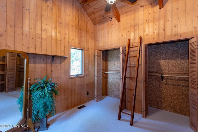 105 Tucker Ct, West End, NC 27376 - unfurnished bedroom with wooden walls, carpet, high vaulted ceiling, beam ceiling, and ceiling fan
