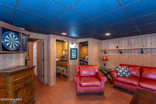 105 Tucker Ct, West End, NC 27376 - living area featuring tile patterned floors, wooden walls, and a paneled ceiling