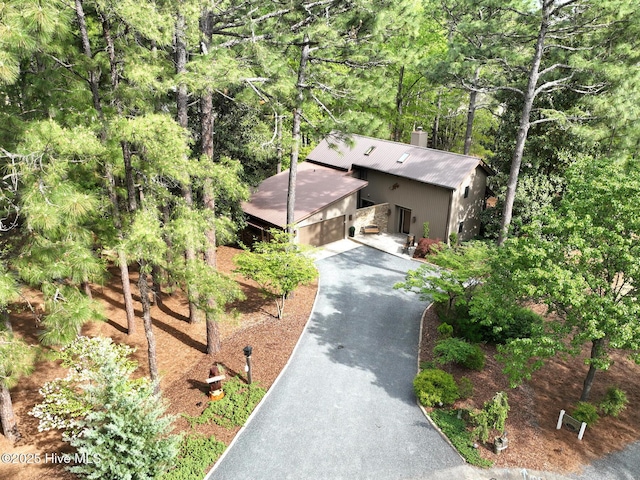 view of front facade with asphalt driveway and a chimney
