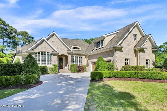 view of front of property featuring concrete driveway, a front lawn, and brick siding