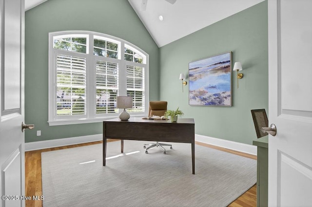 home office with a ceiling fan, baseboards, wood finished floors, and high vaulted ceiling