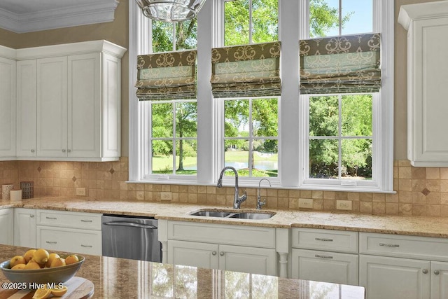 kitchen featuring white cabinets, tasteful backsplash, a sink, and dishwasher
