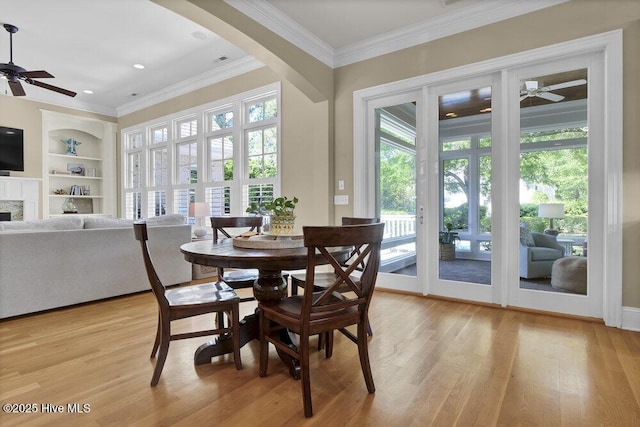 dining area with a healthy amount of sunlight, a ceiling fan, and light wood-style flooring