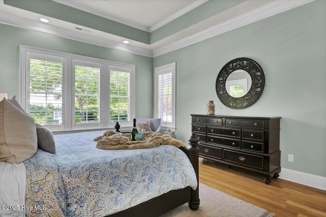 bedroom with visible vents, crown molding, wood finished floors, baseboards, and recessed lighting