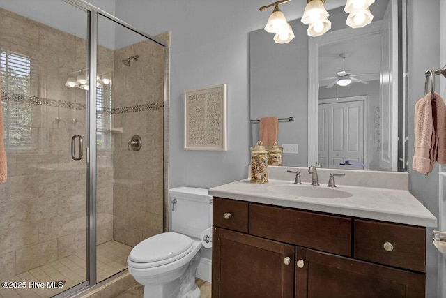 full bath with vanity, a ceiling fan, toilet, and a shower stall