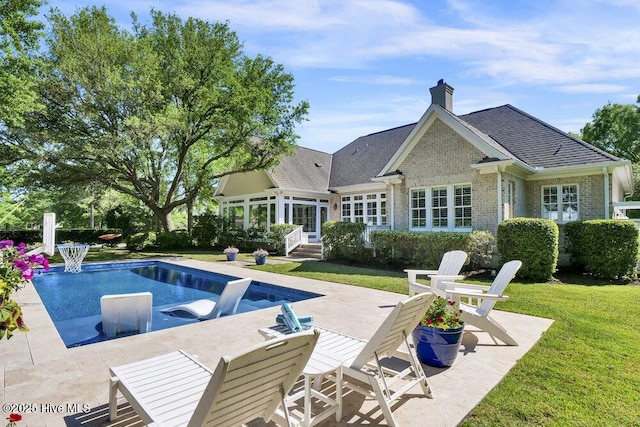 pool with a lawn, a patio area, and a sunroom