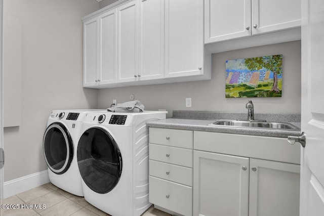 clothes washing area featuring cabinet space, light tile patterned flooring, a sink, baseboards, and washing machine and dryer