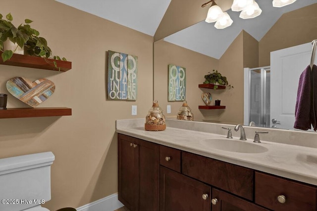 bathroom featuring an inviting chandelier, vanity, toilet, vaulted ceiling, and a stall shower