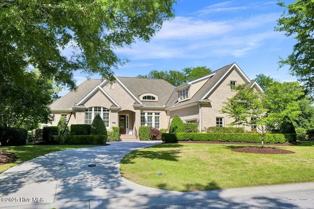 craftsman-style house featuring brick siding and a front lawn