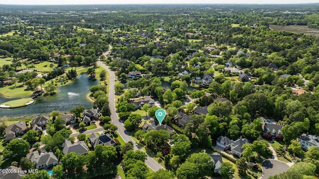 drone / aerial view featuring a water view, a view of trees, and a residential view