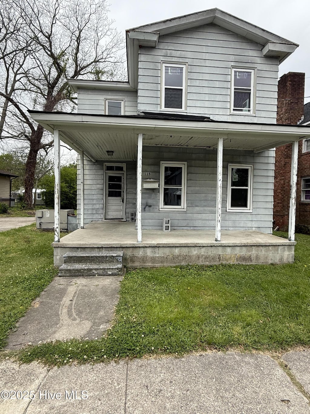 view of front facade featuring a front yard and covered porch