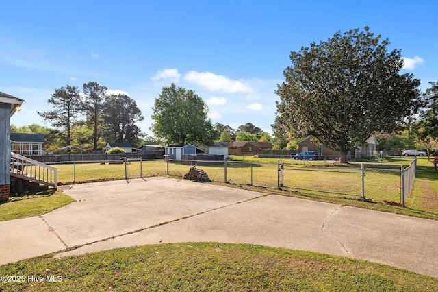 view of yard featuring fence, a patio, and driveway