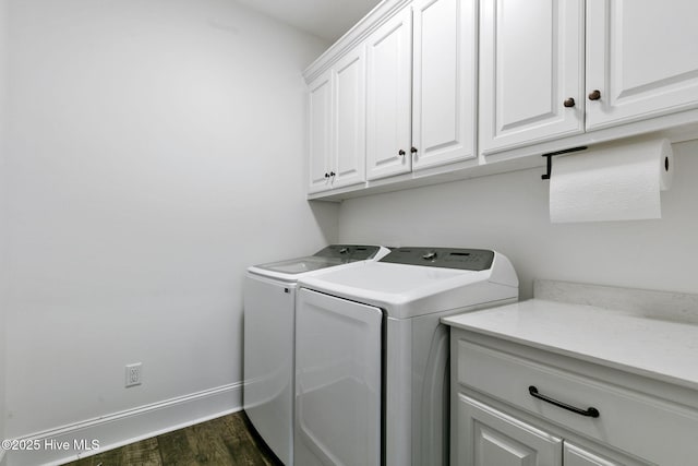 laundry area featuring washing machine and clothes dryer, cabinet space, dark wood-style floors, and baseboards