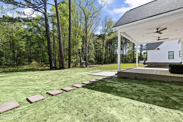 view of yard with ceiling fan and a patio area