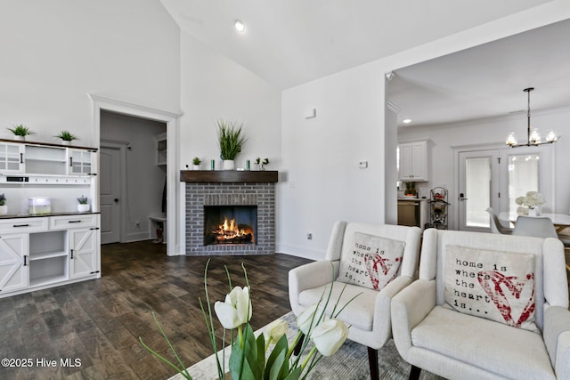 living room featuring recessed lighting, a notable chandelier, lofted ceiling, a fireplace, and dark wood-type flooring