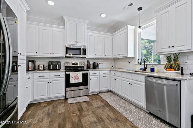 kitchen with stainless steel appliances, visible vents, a sink, decorative backsplash, and white cabinetry