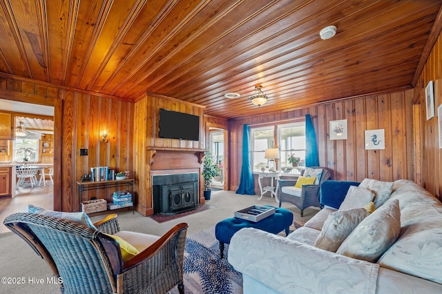 living room featuring a wealth of natural light, wooden ceiling, wood walls, and carpet floors