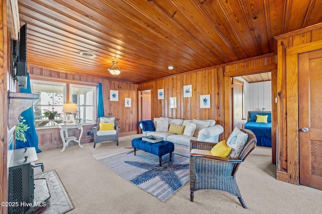 living area featuring wood ceiling, carpet flooring, and wooden walls