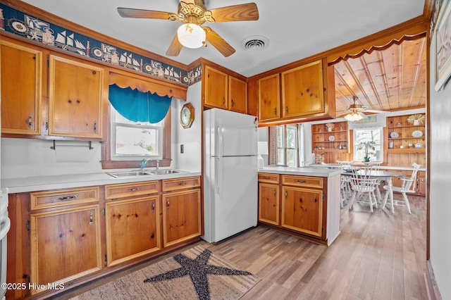 kitchen featuring light countertops, visible vents, a ceiling fan, a sink, and freestanding refrigerator