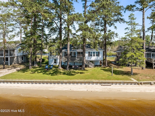 view of front of house with a deck with water view, stairway, and a front yard