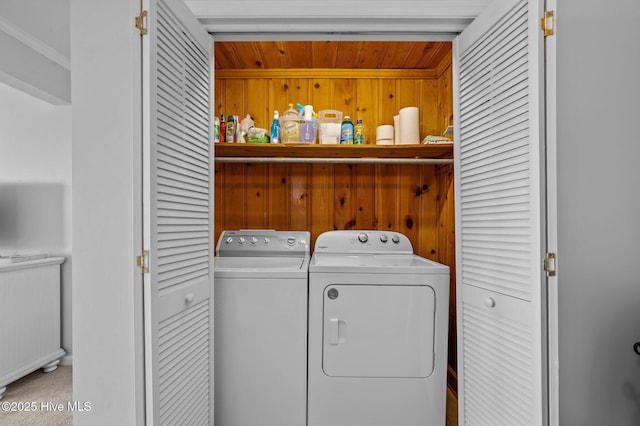 laundry room featuring wood ceiling, wood walls, laundry area, and independent washer and dryer