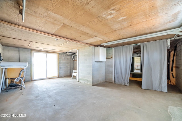 basement featuring concrete block wall and wooden ceiling