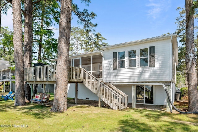 rear view of house with a lawn, a sunroom, a deck, and stairway