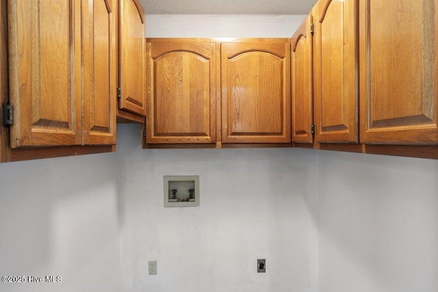 washroom with hookup for a washing machine, hookup for an electric dryer, and cabinet space
