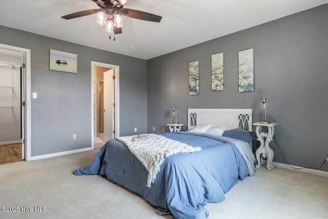 bedroom featuring carpet, ensuite bath, a ceiling fan, and baseboards