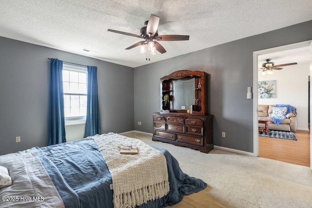 bedroom with visible vents, a ceiling fan, baseboards, a textured ceiling, and carpet flooring