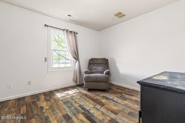 sitting room with dark wood finished floors, baseboards, and visible vents