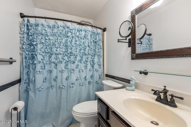 bathroom featuring a shower with shower curtain, a textured ceiling, toilet, and vanity
