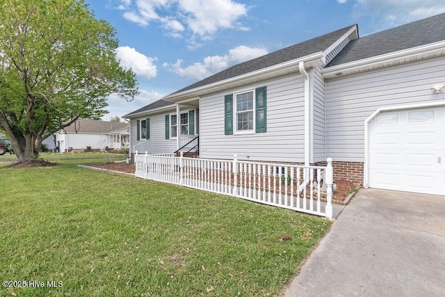 view of front of home with driveway, roof with shingles, a front yard, and a garage