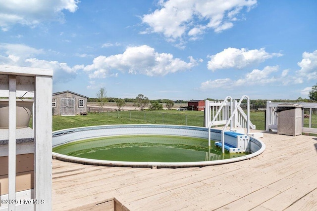 view of pool featuring a lawn, fence, and a deck
