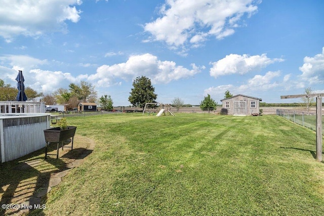 view of yard with a storage shed, an outbuilding, and a fenced backyard