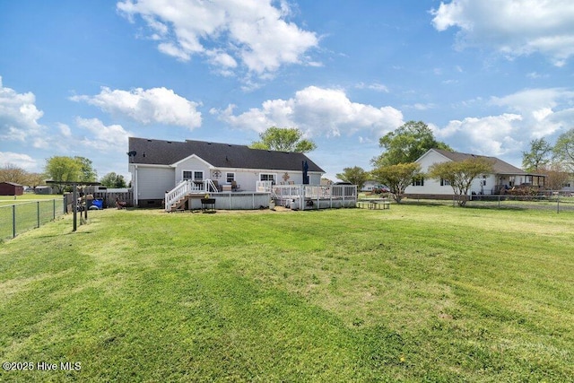rear view of property with a lawn, a fenced backyard, and a deck