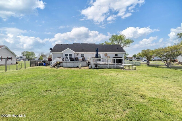 back of property featuring a yard, a fenced backyard, and a deck