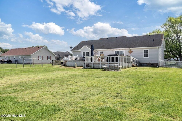 back of property with a lawn, a fenced backyard, crawl space, and a deck