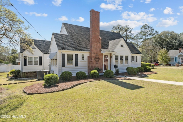 view of front of property featuring central AC, a front lawn, and a chimney
