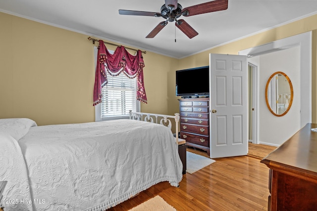bedroom featuring ceiling fan, crown molding, and wood finished floors