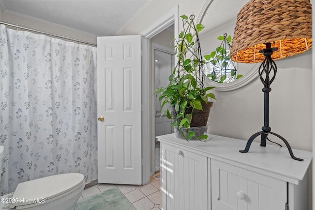 bathroom featuring tile patterned flooring, crown molding, toilet, and a shower with curtain