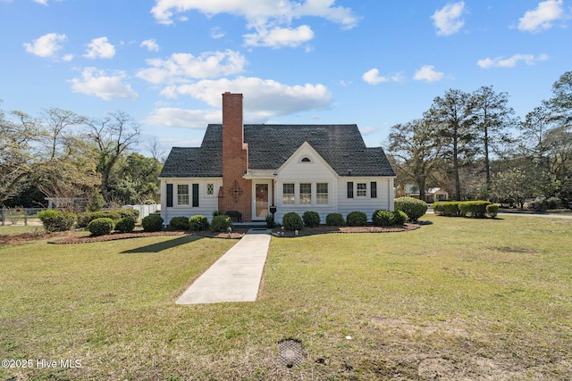view of front of house featuring a chimney, a front lawn, and fence